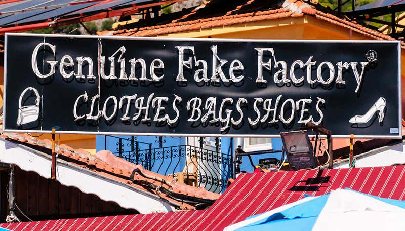 Sign reading "Genuine fake factory, clothes bag shoes"