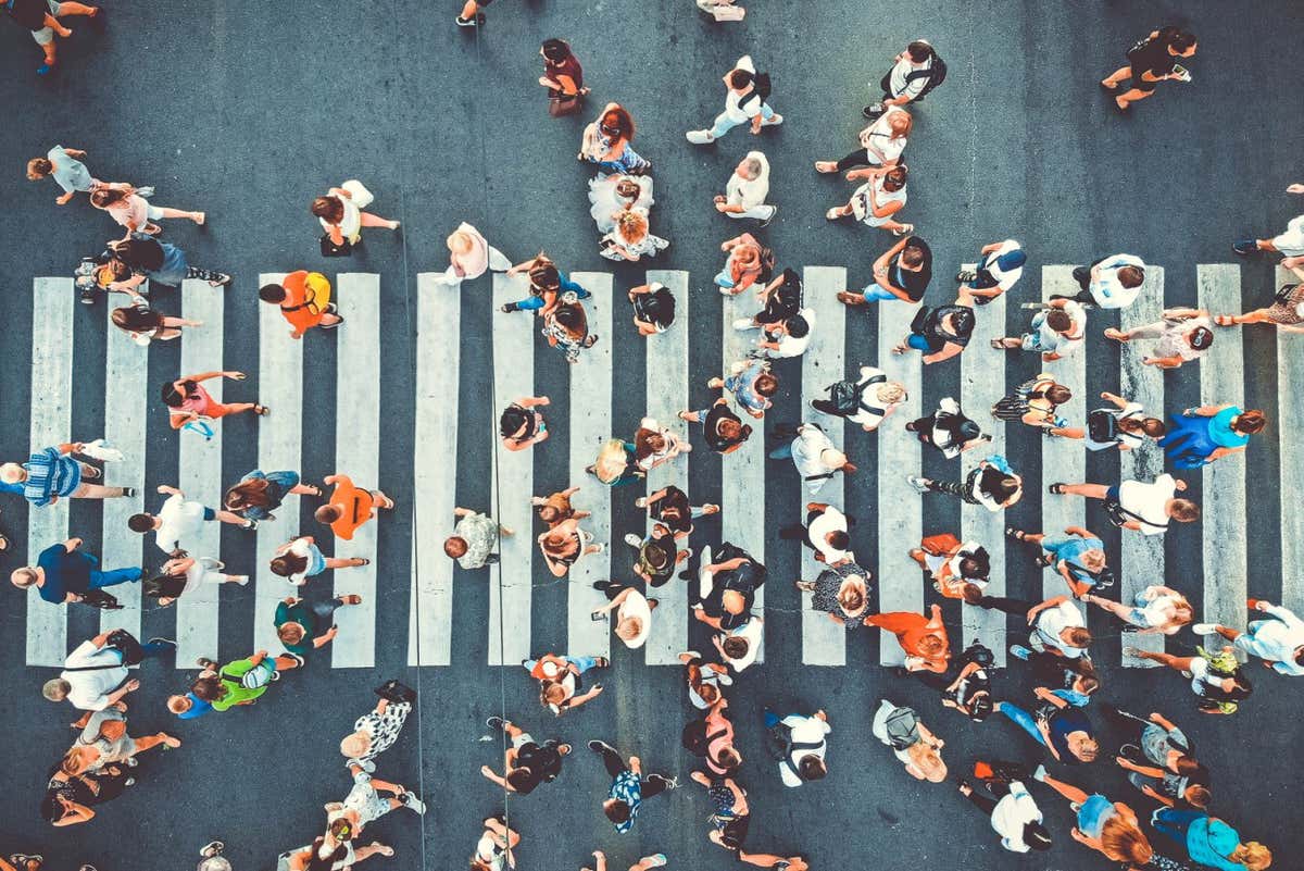 Aerial. People crowd on pedestrian crosswalk. Top view background. Toned image.